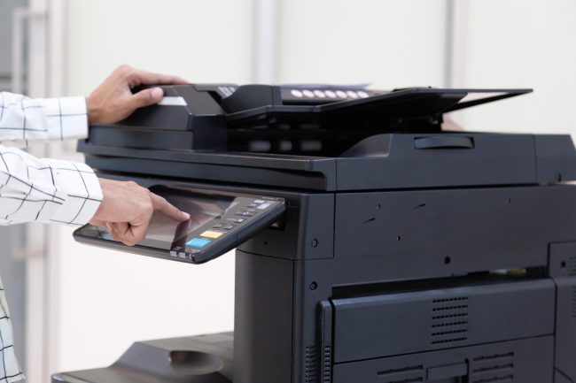 Bussinessman press button on panel of printer photocopier