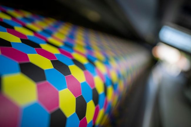 digital vs offset printing Close-up of a CMYK honeycomb pattern on a printer roller for digital vs offset printing.